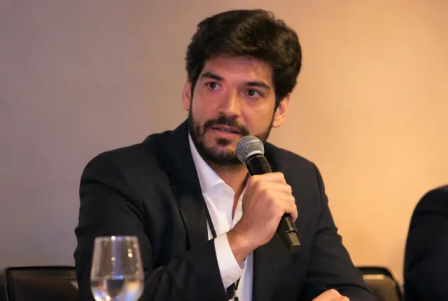 Palestrante falando ao microfone em um painel