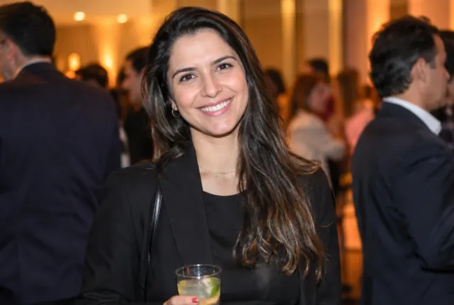 Convidada sorrindo durante um evento corporativo