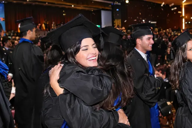 Formandos se abraçando após a cerimônia de formatura